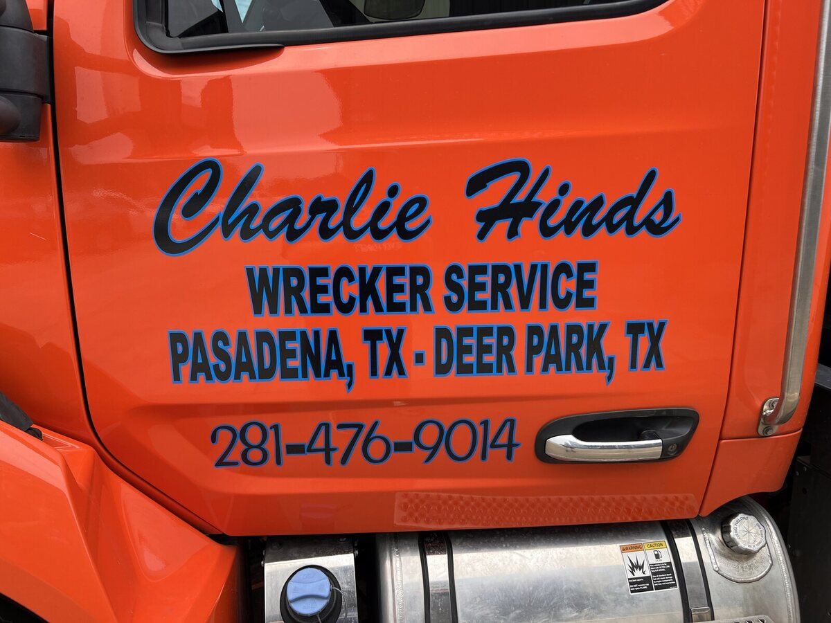 Charlie Hinds Wrecker Service lettering on the door of an orange tow truck
